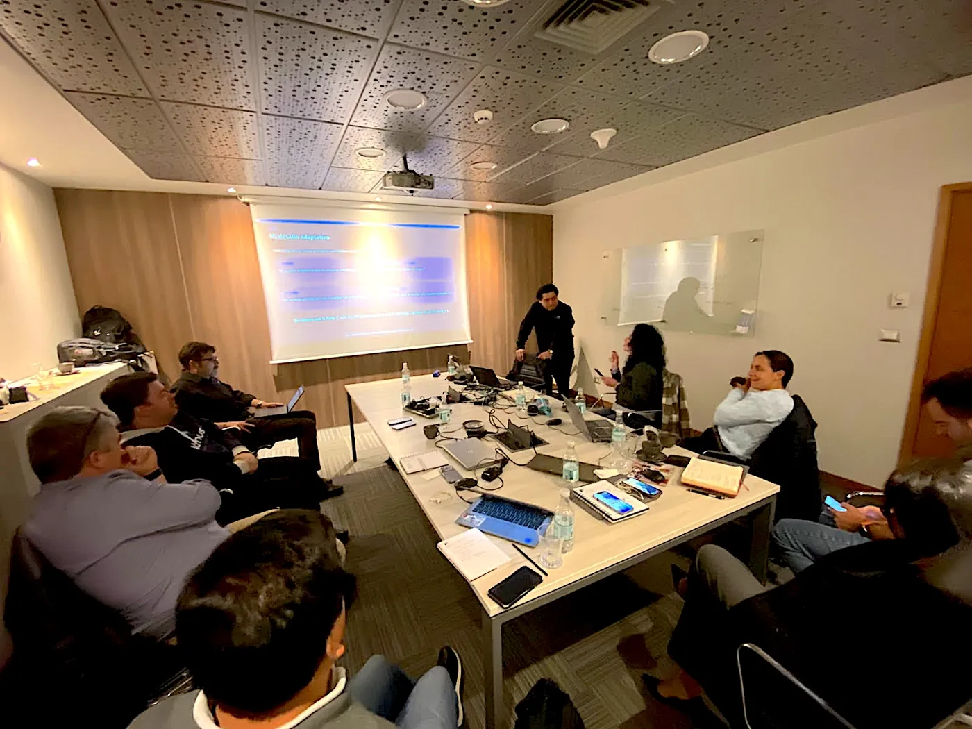 Equipo de Think4Change reunido en un taller de trabajo, dialogando alrededor de una mesa en un ambiente industrial con una sensación colaborativa y enfocada